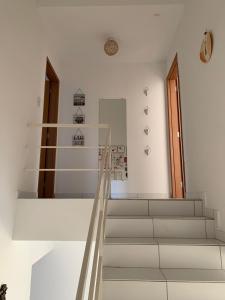 un conjunto de escaleras en una habitación blanca en Duplex com 02 Suítes e Ar-Condicionados en Bananeiras