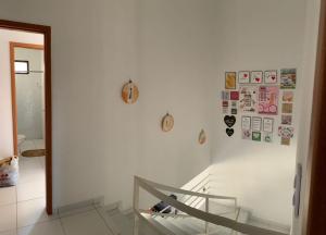 ein Zimmer mit einer weißen Wand mit Bildern an der Wand in der Unterkunft Duplex com 02 Suítes e Ar-Condicionados in Bananeiras