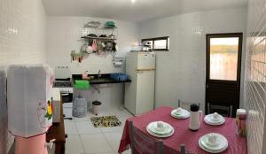 a small kitchen with a table and a refrigerator at Lar da Serra Duplex com 02 Suites com ar in Bananeiras