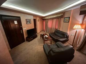 sala de estar con sofá, mesa y TV en 7 Wonders Hotel, en Wadi Musa
