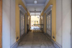 pusty korytarz z żółtymi ścianami i drzwiami w obiekcie Castello Luxury Apartment - in the heart of Milan w Mediolanie