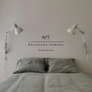 een slaapkamer met 2 lampen boven een bed bij Nº7 Sacadura Cabral in Guarda