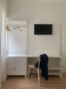 a desk with a blue jacket on a chair in a room at Nº7 Sacadura Cabral in Guarda