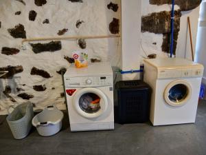 a washing machine and a washer in a room at Casa do Marcelino Lagarto in São Roque do Pico