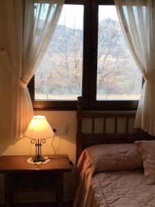 sypialnia z łóżkiem i stołem z lampką w obiekcie Casa Rural Fuentecillas w mieście Becedas