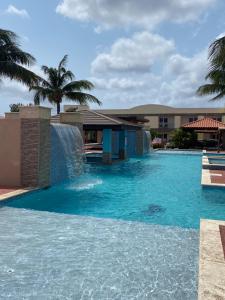 a swimming pool with a waterfall and a fountain at Pearl Aruba in Palm-Eagle Beach