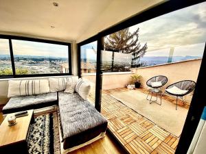 ein Wohnzimmer mit einem Sofa und großen Fenstern in der Unterkunft Appartement d’exception vue panoramique in Nizza