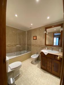 a bathroom with a toilet and a tub and a sink at A Casa Do Patín Cangas in Cangas de Morrazo +36 photos