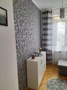 a living room with a white cabinet and a wall at Apartament ADA in Koszalin