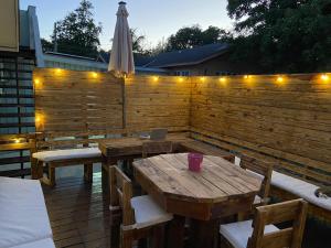 a patio with wooden tables and a fence with lights at Elegant Marble Suite #6 in Nassau