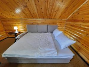 uma cama num quarto com tecto em madeira em Chill pill and billiards - Сеть апартаментов Alex Apartments Бесконтактное заселение 24-7 em Poltava
