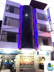um edifício com luzes roxas na parte da frente em Hostal Bryana Inn Baños em Baños
