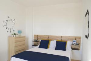 a bedroom with a large bed with blue and yellow pillows at ONDA BLU-Appartamenti in Torre dell'Orso