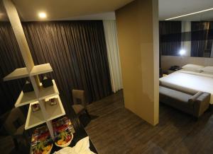 une chambre d'hôtel avec un lit et une table avec de la nourriture dans l'établissement e.City Hotel@OneCity, à Subang Jaya