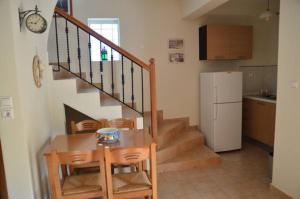 a kitchen with a staircase and a table and a refrigerator at Steni Vala Apartments in Steni Vala Alonissos
