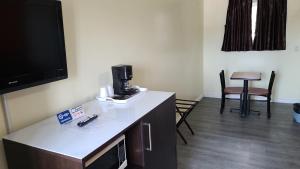 um quarto com uma mesa e comodidades para preparar café em Norvic Motel em Coniston