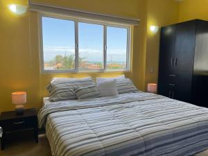 a bedroom with a large bed with a large window at Posada Paraiso in El Yaque
