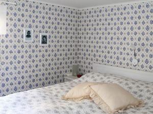 Schlafzimmer mit einem Bett mit einer blauen und weißen Tapete in der Unterkunft Holiday home Fjärås II in Fjärås