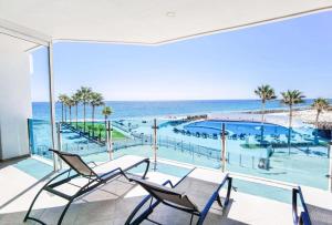 a balcony with a view of a pool and the ocean at Esmeralda by TO in Puerto Peñasco