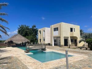 a house with a swimming pool in front of a building at Posada Paraiso in El Yaque