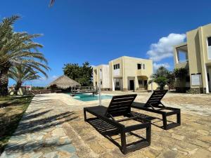 two black chairs sitting in front of a house at Posada Paraiso in El Yaque