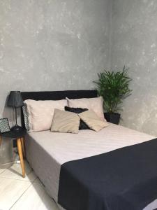 Una cama con dos almohadas y una planta. en LOFT RIO, en Río de Janeiro