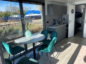 una cocina con mesa, sillas y un jarrón. en Waterfront houseboat in Monnickendam near the centre, en Monnickendam