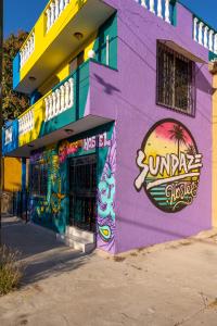 a purple building with graffiti on the side of it at Sundaze Homestay in Mazatlán