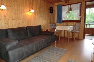 sala de estar con sofá de cuero y mesa en Bootshaus, Mirow, en Mirow