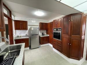 a kitchen with wooden cabinets and stainless steel appliances at Eucaliptos 1102 in Lima