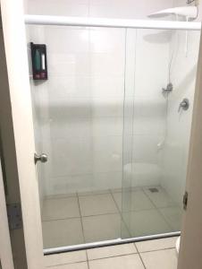 um chuveiro com uma porta de vidro na casa de banho em Flat Aldeia das Águas em Barra do Piraí