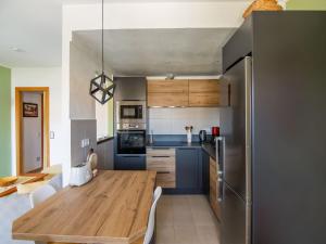 a kitchen with a wooden table and a dining room at Belvilla by OYO Sant Pere Playa in Sant Pere Pescador