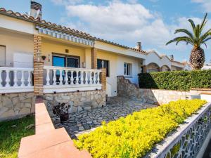 una casa con una valla blanca y flores amarillas en Belvilla by OYO Sant Pere Playa, en Sant Pere Pescador