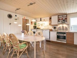 een keuken en eetkamer met een tafel en stoelen bij Holiday home Hals CXI in Hals