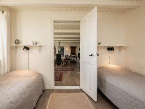 1 dormitorio con 2 camas y pasillo con mesa en Holiday home Løkken CLXVI, en Løkken