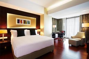 a bedroom with a bed and a desk and a chair at Amari Dhaka in Dhaka