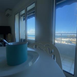 Una habitación con una mesa y sillas y una ventana. en L'Imperial, en Le Grau-du-Roi