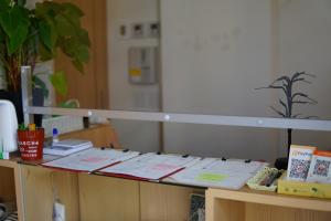 a table with papers and books on top of it at Guesthouse COCO Hiroshima (Female Only) in Hiroshima