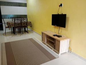 ein Wohnzimmer mit einem Flachbild-TV an der Wand in der Unterkunft Rumah Tamu Pekan (semi D) in Pekan