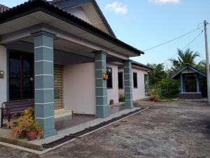 ein Haus mit blauen und weißen Säulen in der Unterkunft Rumah Tamu Pekan (semi D) in Pekan