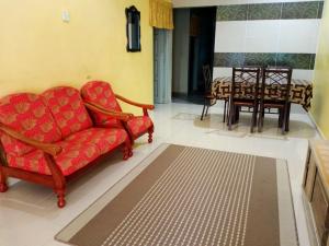 ein Wohnzimmer mit einem roten Sofa und einem Tisch in der Unterkunft Rumah Tamu Pekan (semi D) in Pekan