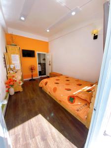 1 dormitorio con 1 cama naranja en una habitación en Suri's House Homestay, en Da Lat