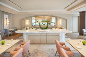 a dining room with a large table with a green centerpiece at Four Seasons Hotel Tokyo at Marunouchi in Tokyo +38 photos