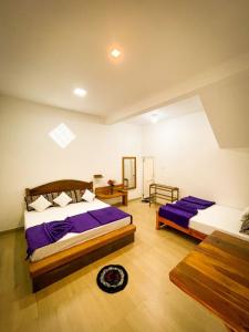 a bedroom with two beds with purple sheets at Gimanhala Diyathalawa in Diyatalawa