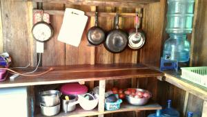 a shelf with pots and pans and other kitchen items at Cabanas Rusticas in Las Peñitas