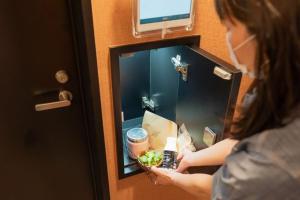 a woman standing in a hotel room with a mirror at Kamishihoro Hotel in Kami-shihoro