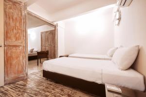 Habitación de hotel con cama y espejo en Laurdhomes Duplex Old City, Plaza Santo Domingo en Cartagena de Indias