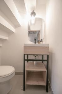 a bathroom with a toilet and a sink and a mirror at Laurdhomes Duplex Old City, Plaza Santo Domingo in Cartagena de Indias