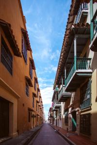 una calle vacía en un callejón entre dos edificios en Laurdhomes Duplex Old City, Plaza Santo Domingo, en Cartagena de Indias
