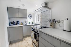 a kitchen with white counters and a stove top oven at Comfy Dales holiday base on Market Place of historic market town in Richmond